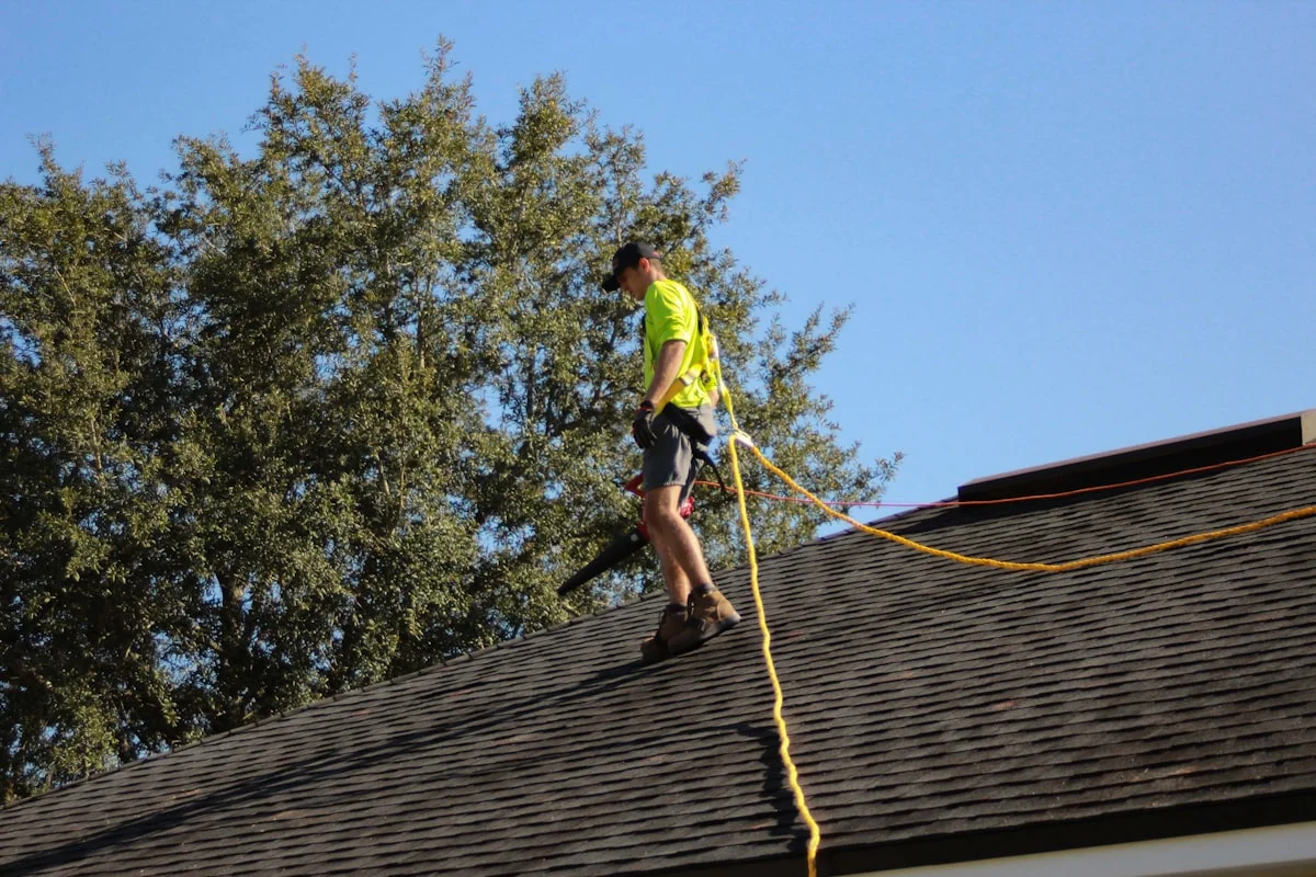 Roofing professional conducting annual roof inspection on residential home